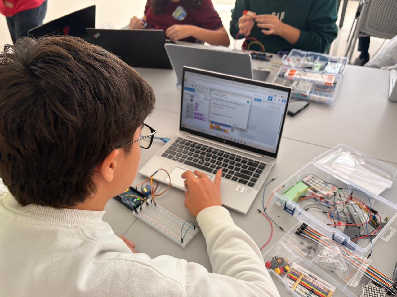 Estudiantes trabajan con tecnología en una experiencia de aprendizaje práctico